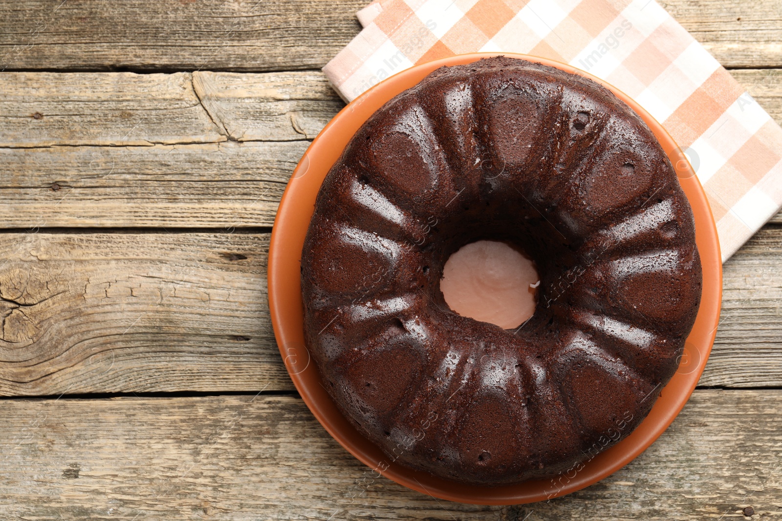 Tasty chocolate bundt cake on wooden table, top view. Space for text Photo of Tasty chocolate bundt cake on wooden table, top view. Space for text