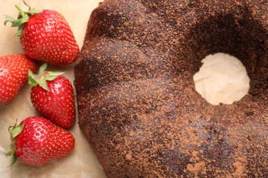 Photo of Tasty chocolate bundt cake and strawberries on table, flat lay