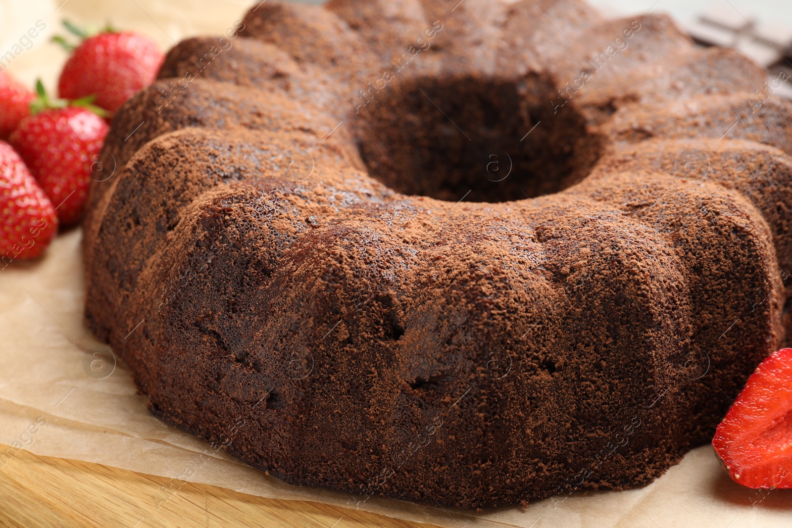 Tasty chocolate bundt cake and strawberries on table, closeup Photo of Tasty chocolate bundt cake and strawberries on table, closeup