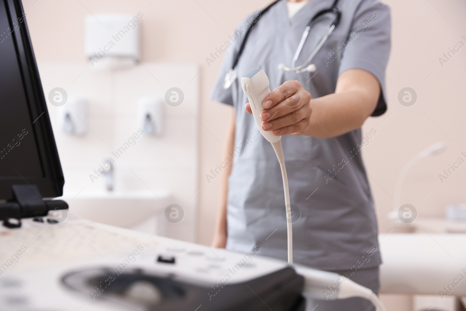 Sonographer with transducer and ultrasound machine in clinic, closeup Photo of Sonographer with transducer and ultrasound machine in clinic, closeup