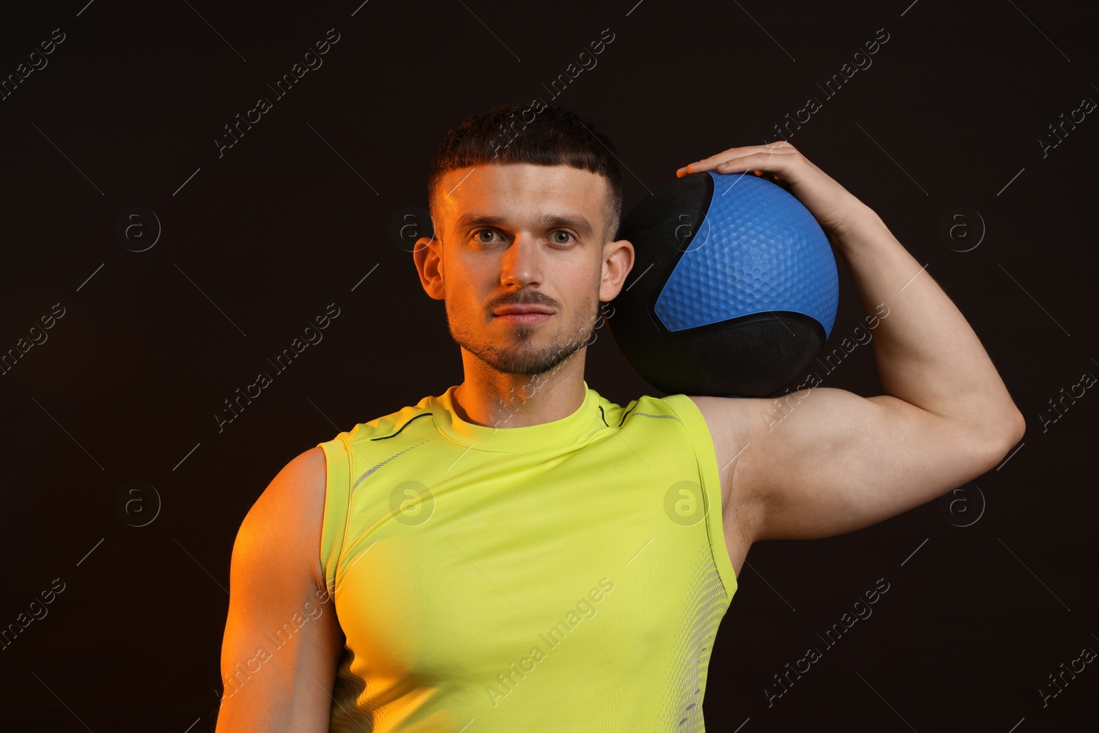 Man with medicine ball on black background Photo of Man with medicine ball on black background