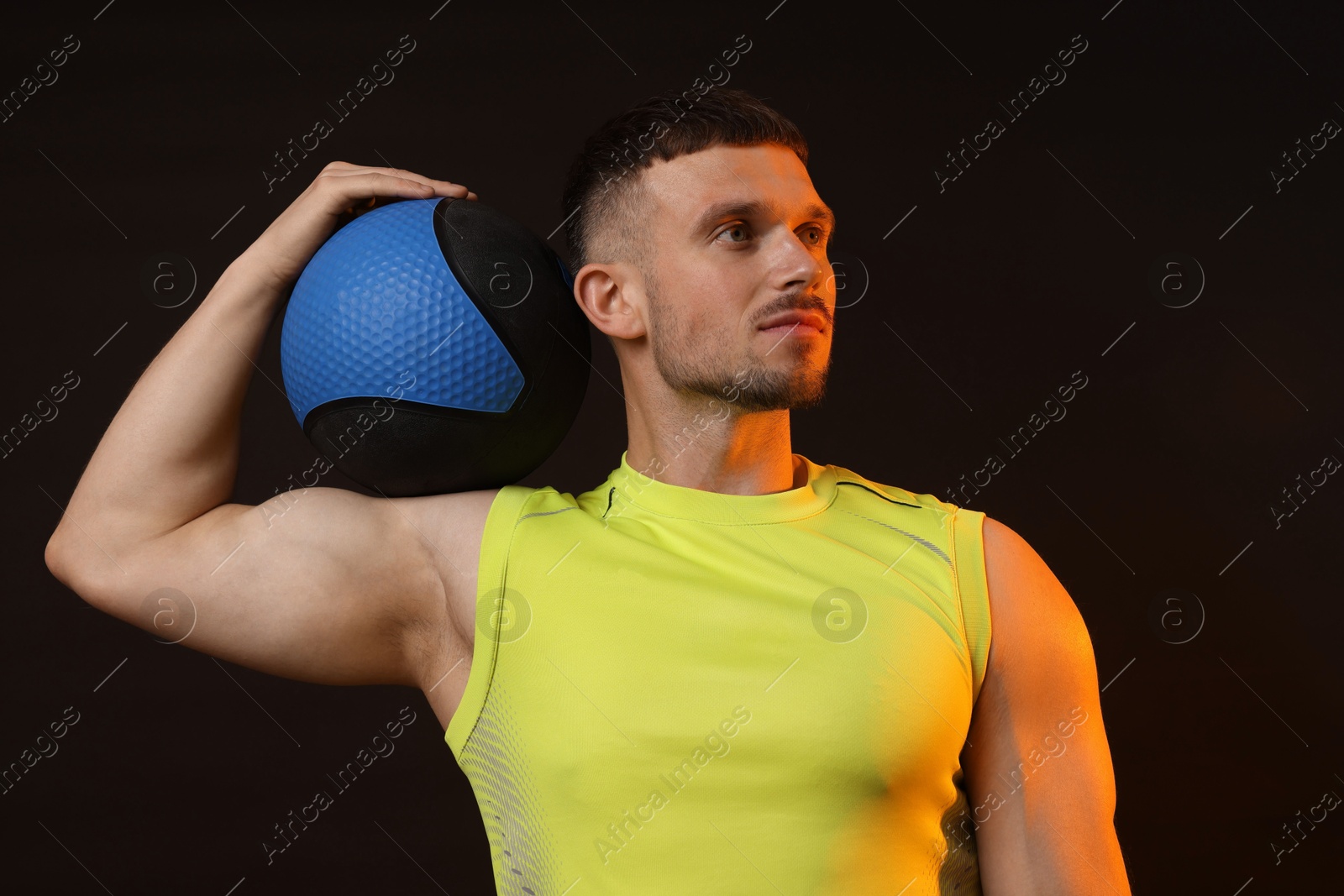 Man with medicine ball on black background Photo of Man with medicine ball on black background