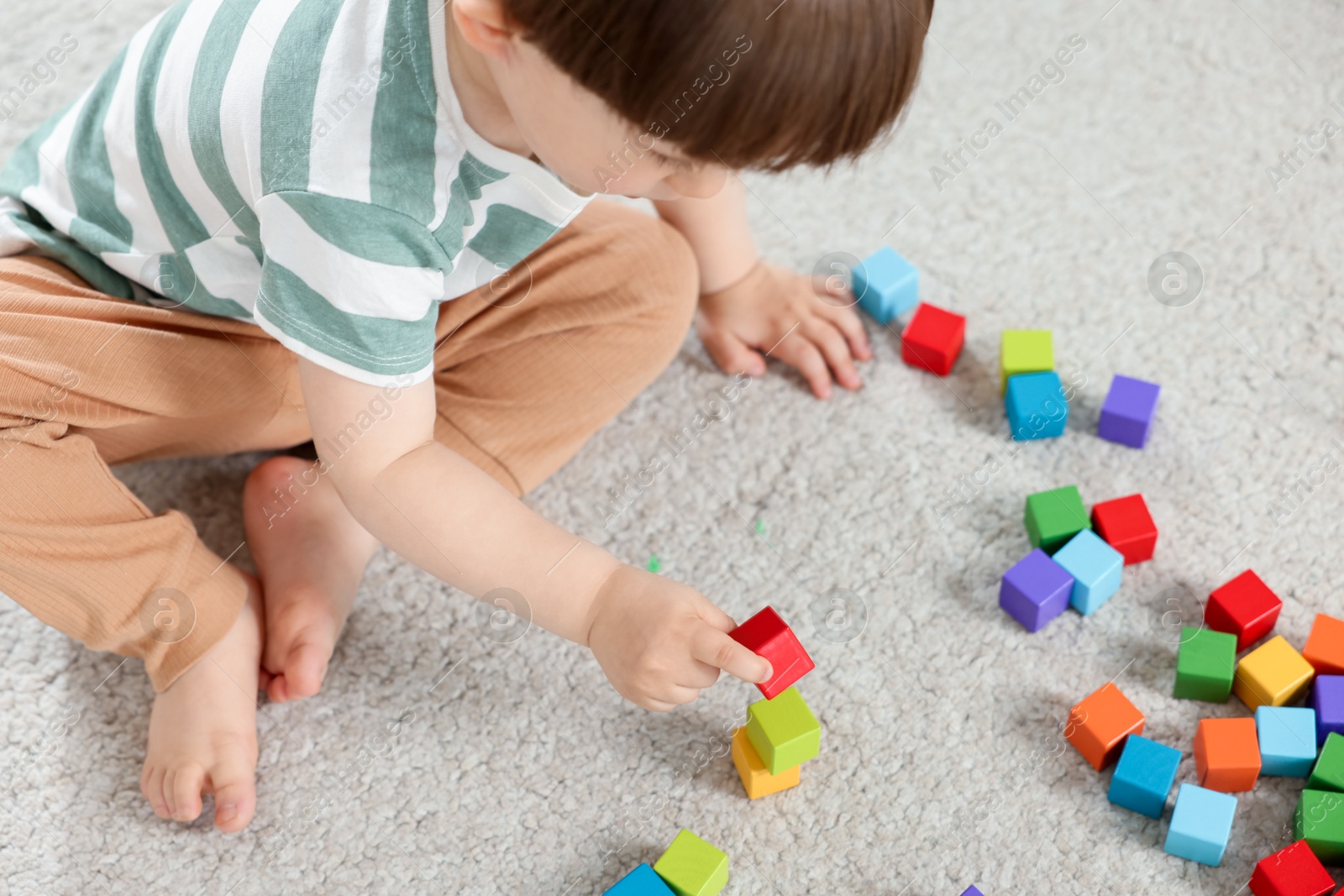 Cute little child playing with colorful cubes at home, above view Photo of Cute little child playing with colorful cubes at home, above view
