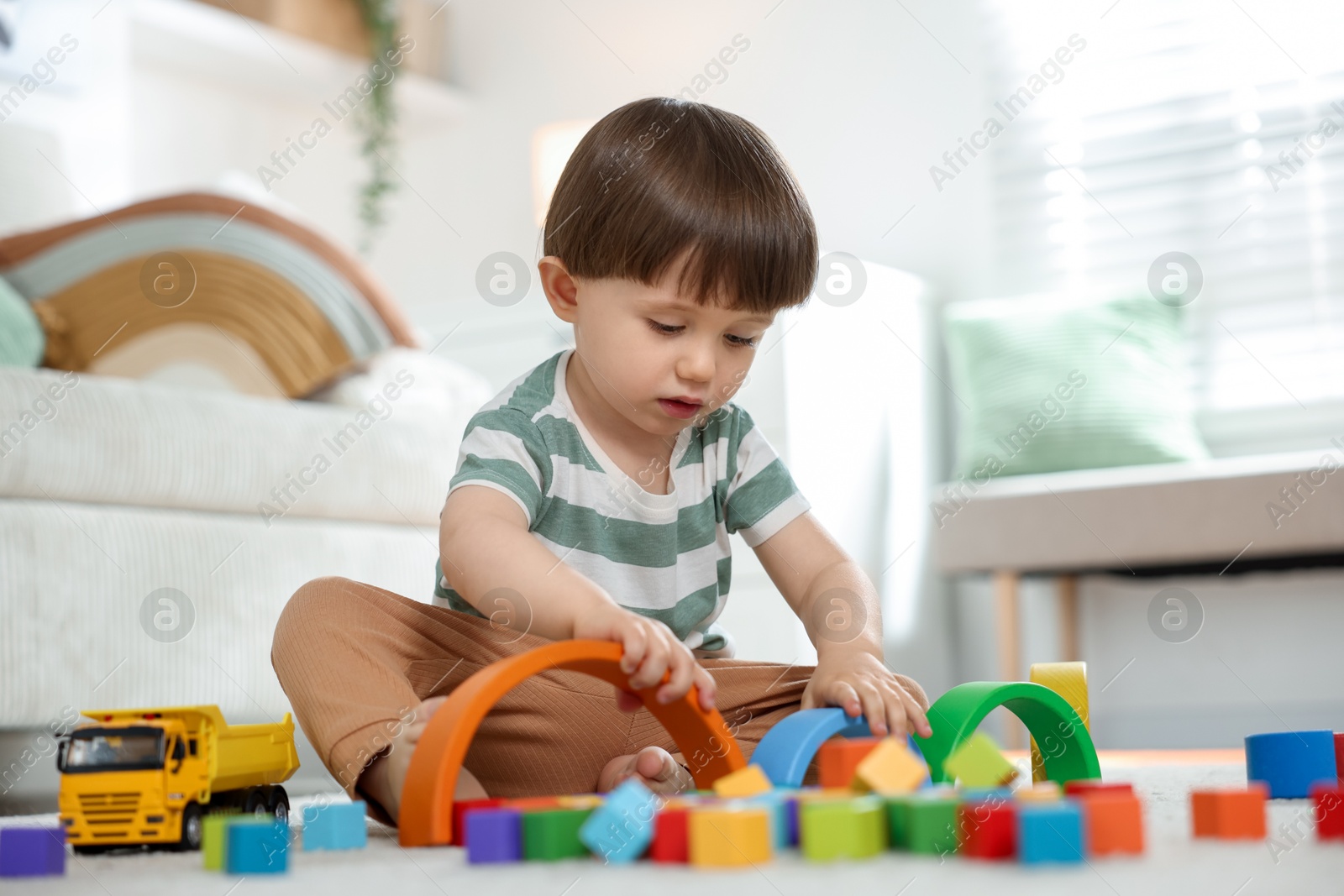 Cute little child playing with colorful cubes at home Photo of Cute little child playing with colorful cubes at home