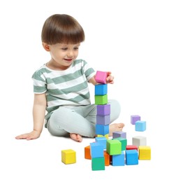 Photo of Cute little child playing with colorful cubes on white background