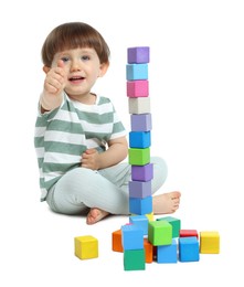 Photo of Cute little child playing with colorful cubes on white background