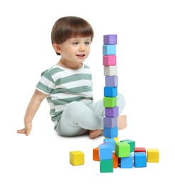 Photo of Cute little child playing with colorful cubes on white background