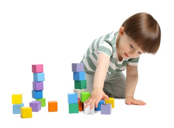 Photo of Cute little child playing with colorful cubes on white background