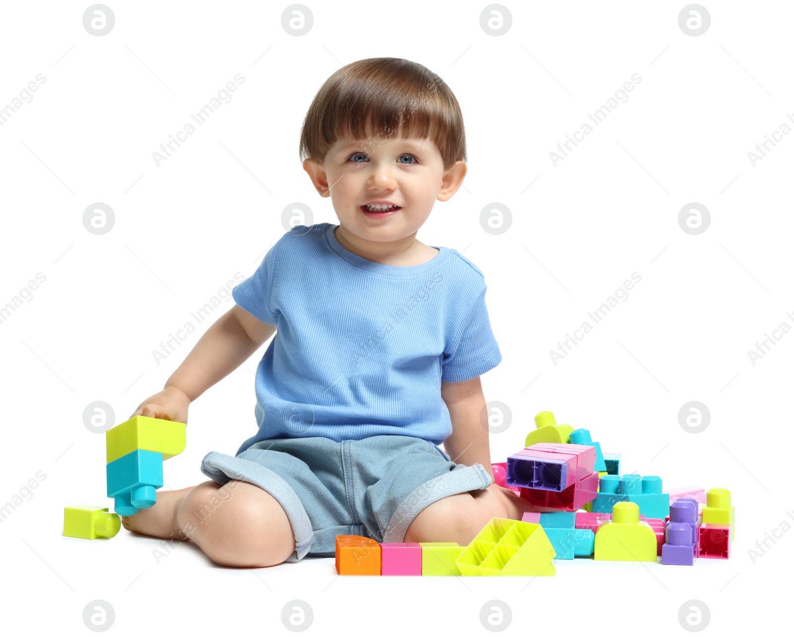 Cute little boy playing with building bricks on white background Photo of Cute little boy playing with building bricks on white background