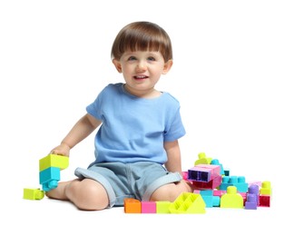 Photo of Cute little boy playing with building bricks on white background