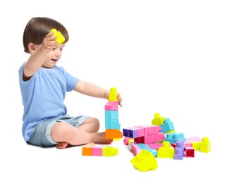 Photo of Cute little boy playing with building bricks on white background