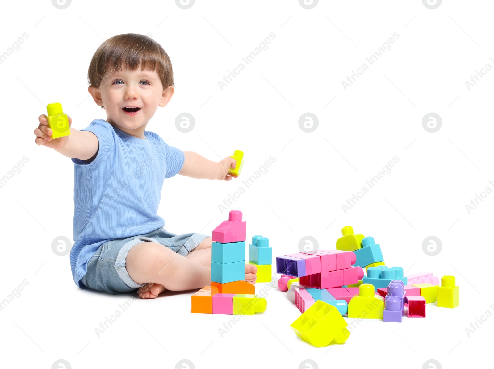Cute little boy playing with building bricks on white background Photo of Cute little boy playing with building bricks on white background