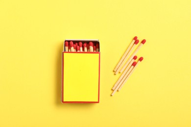 Photo of Matches and box on yellow background, flat lay. Mockup for design