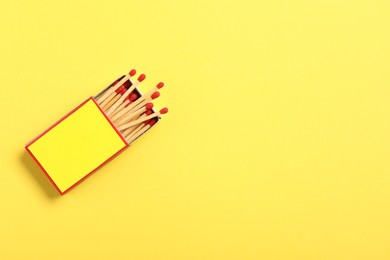 Photo of Matches in box on yellow background, top view. Mockup for design