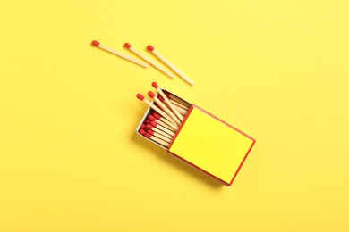 Photo of Matches and box on yellow background, flat lay. Mockup for design