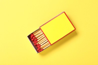 Photo of Matches in box on yellow background, top view. Mockup for design