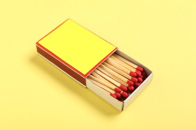 Photo of Matches in box on yellow background, closeup. Mockup for design