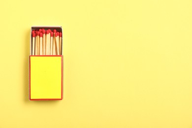 Photo of Matches in box on yellow background, top view. Mockup for design