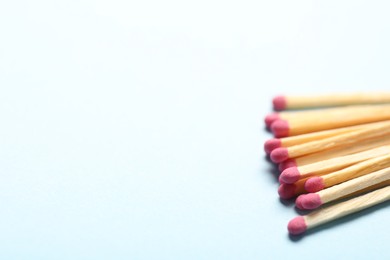 Photo of Matches with pink heads on light background, closeup. Space for text
