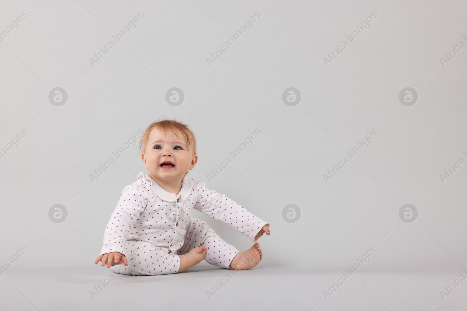 Cute little baby on light grey background, space for text Photo of Cute little baby on light grey background, space for text