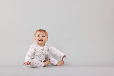 Photo of Cute little baby on light grey background, space for text