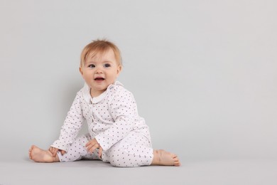 Photo of Cute little baby on light grey background, space for text