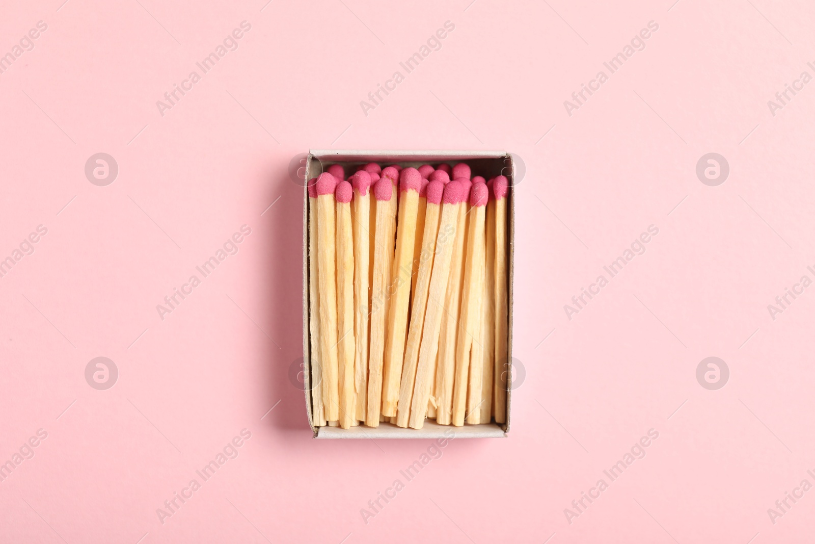 Matches in box on pink background, top view Photo of Matches in box on pink background, top view