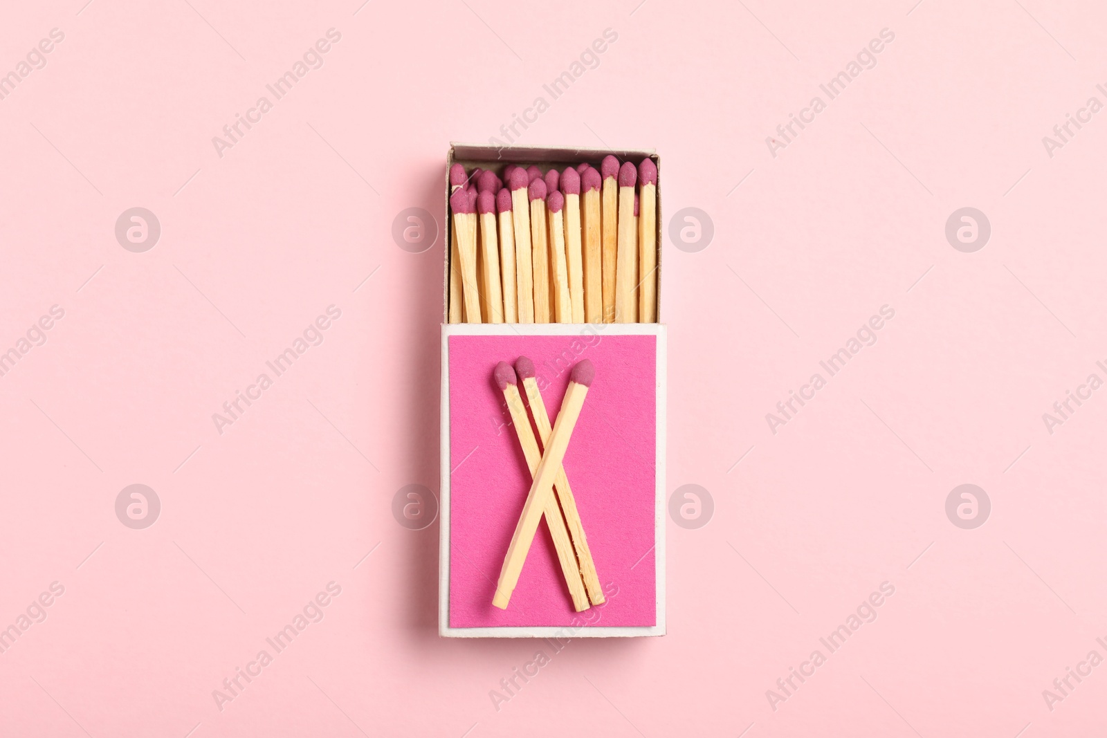 Matches and box on pink background, top view Photo of Matches and box on pink background, top view
