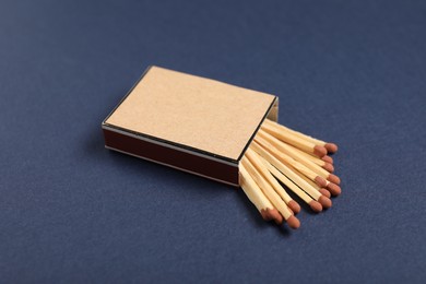Photo of Matches in box on blue background, closeup. Mockup for design