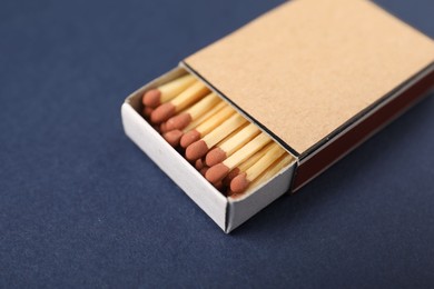 Photo of Matches in box on blue background, closeup. Mockup for design