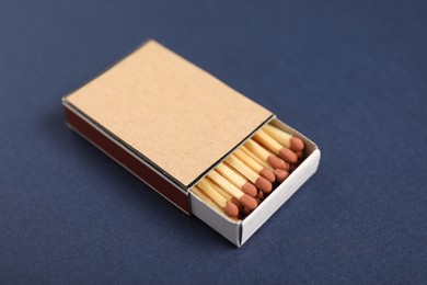 Photo of Matches in box on blue background, closeup. Mockup for design
