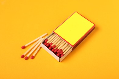 Photo of Matches and box on yellow background, closeup. Mockup for design