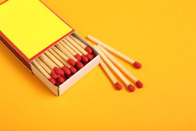 Photo of Matches and box on yellow background, closeup. Mockup for design