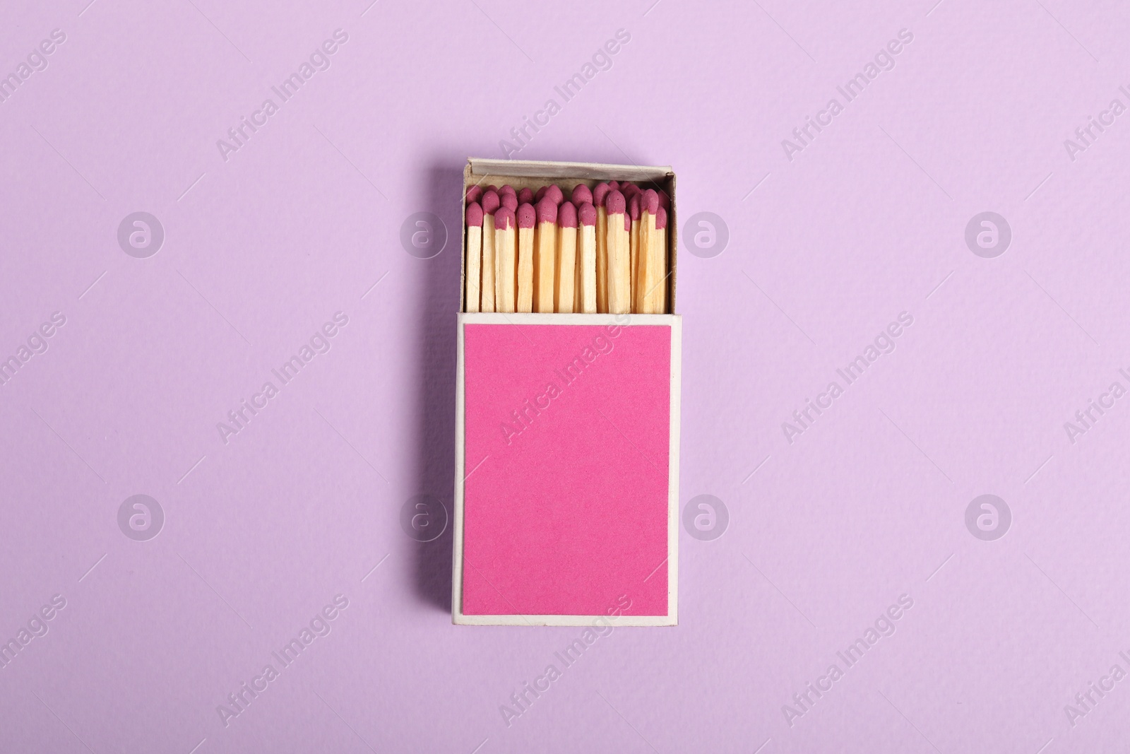 Photo of Matches in box on violet background, top view. Mockup for design