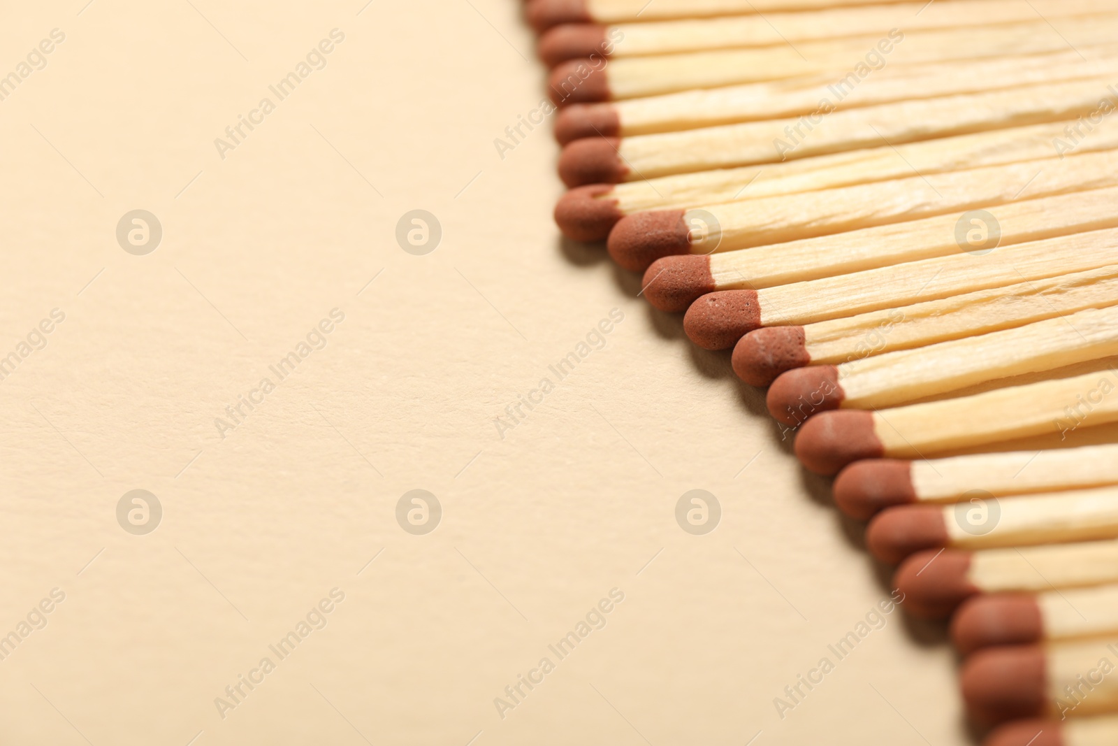 Matches with brown heads on beige background, closeup. Space for text Photo of Matches with brown heads on beige background, closeup. Space for text