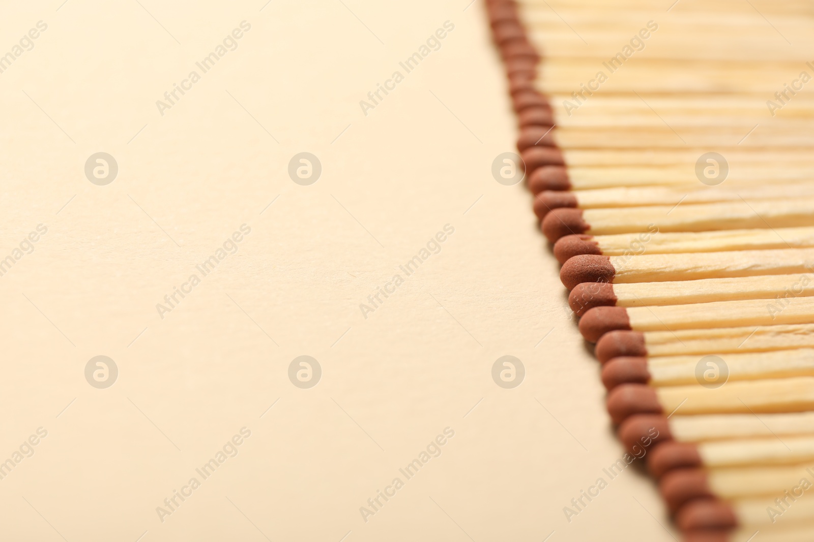 Matches with brown heads on beige background, closeup. Space for text Photo of Matches with brown heads on beige background, closeup. Space for text