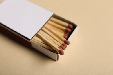 Photo of Matches in box on beige background, closeup. Mockup for design