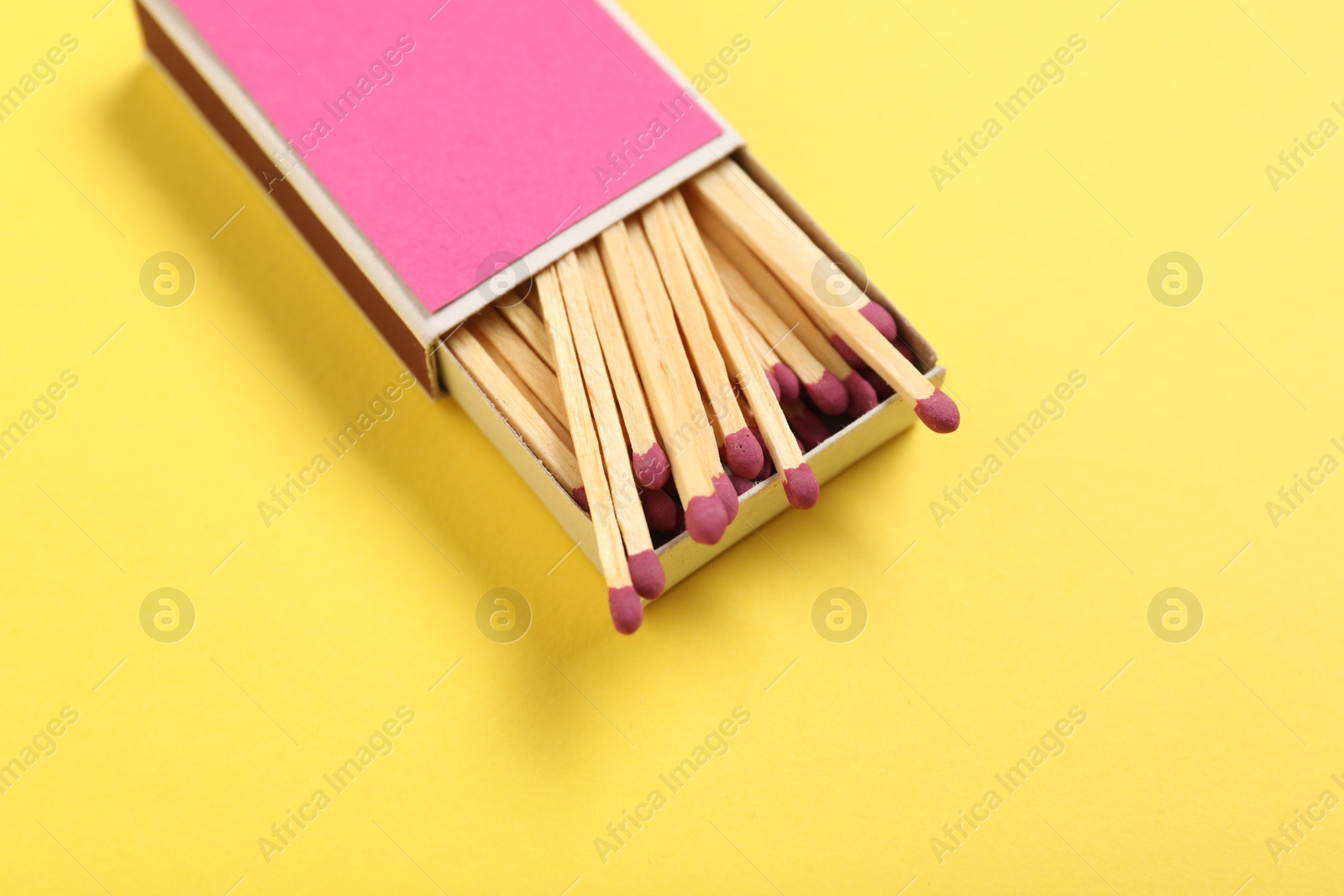 Matches in box on yellow background, above view. Mockup for design Photo of Matches in box on yellow background, above view. Mockup for design