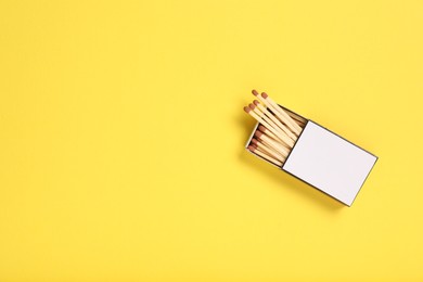 Photo of Matches in box on yellow background, top view. Mockup for design