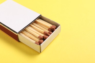 Photo of Matches in box on yellow background, closeup. Mockup for design