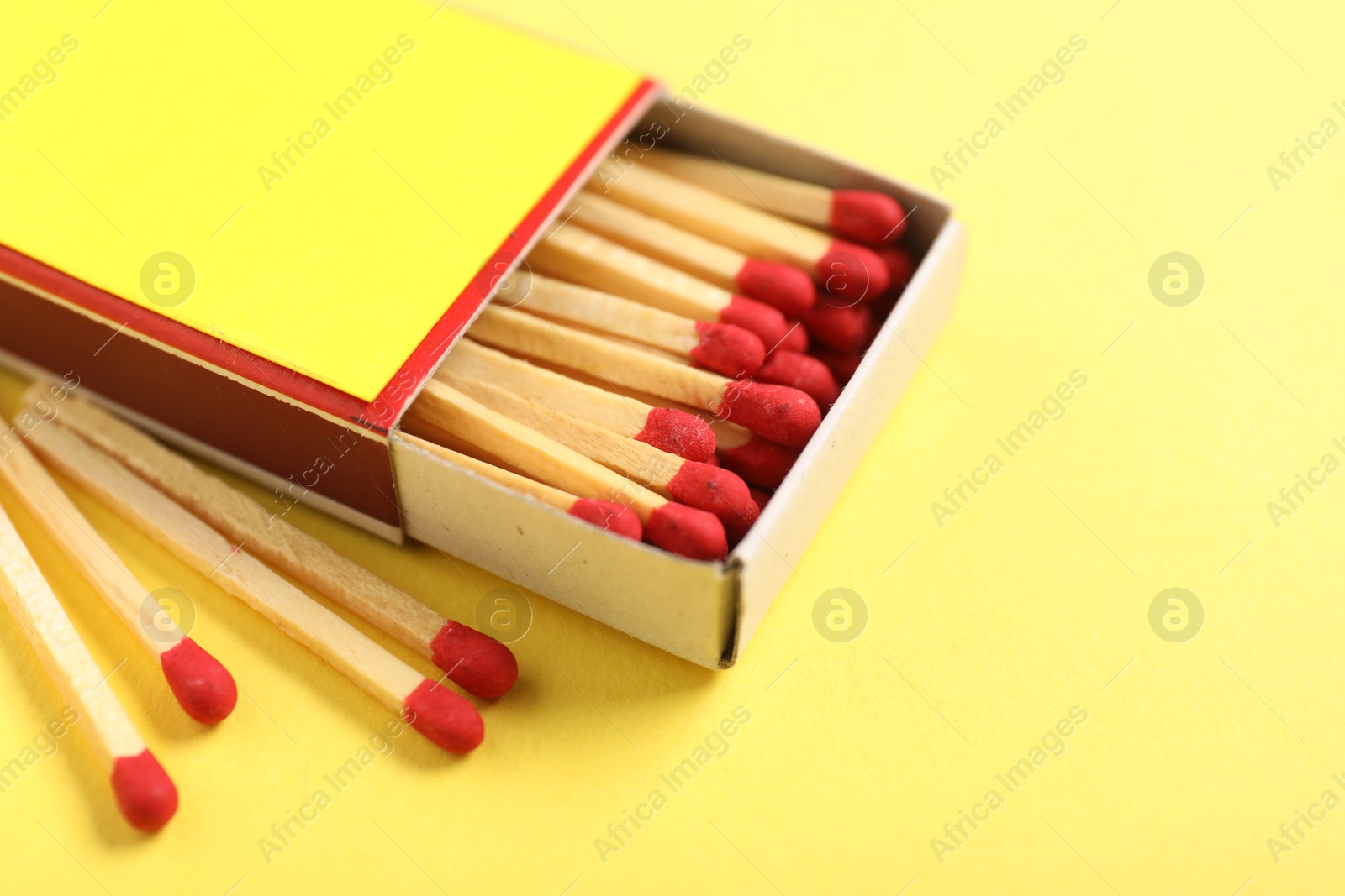 Photo of Matches in box on yellow background, closeup