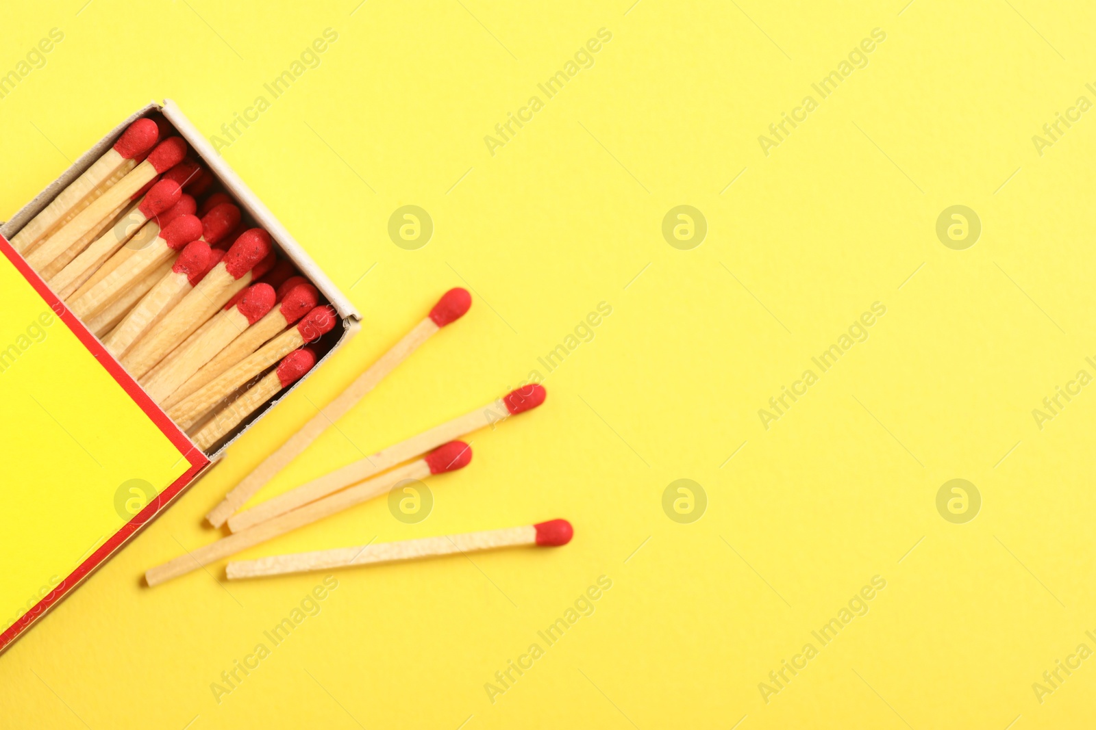 Matches and box on yellow background, flat lay. Space for text Photo of Matches and box on yellow background, flat lay. Space for text