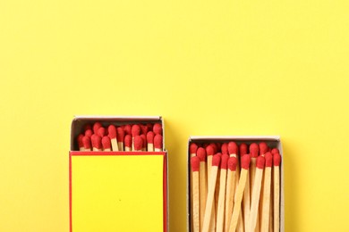 Photo of Matches and boxes on yellow background, flat lay. Mockup for design