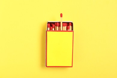 Photo of Matches in box on yellow background, top view. Mockup for design