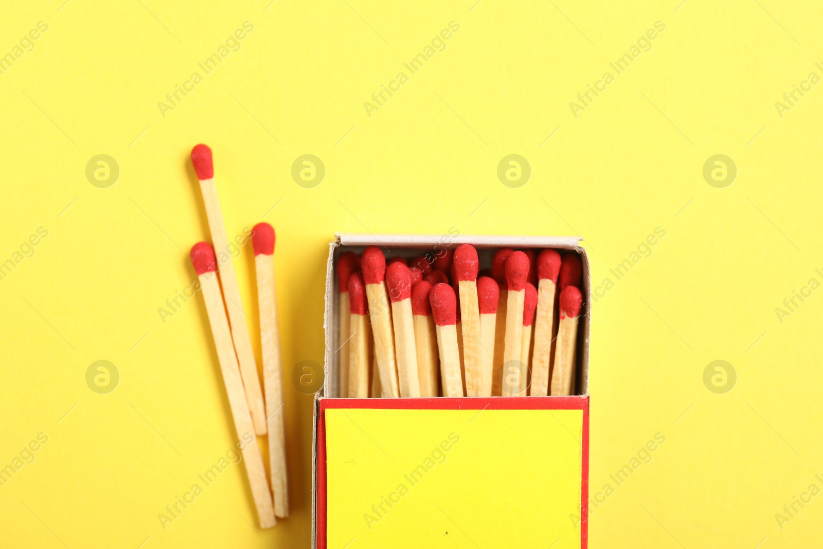Matches and box on yellow background, flat lay. Mockup for design Photo of Matches and box on yellow background, flat lay. Mockup for design