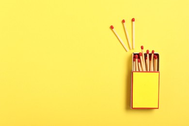Photo of Matches and box on yellow background, flat lay. Mockup for design