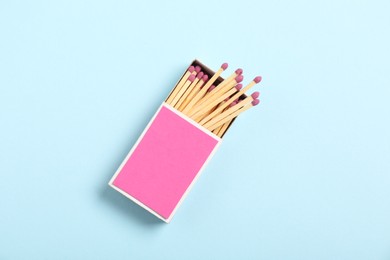 Photo of Matches in box on light blue background, top view. Mockup for design