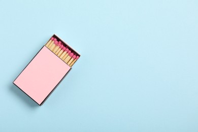 Photo of Matches in box on light blue background, top view. Mockup for design