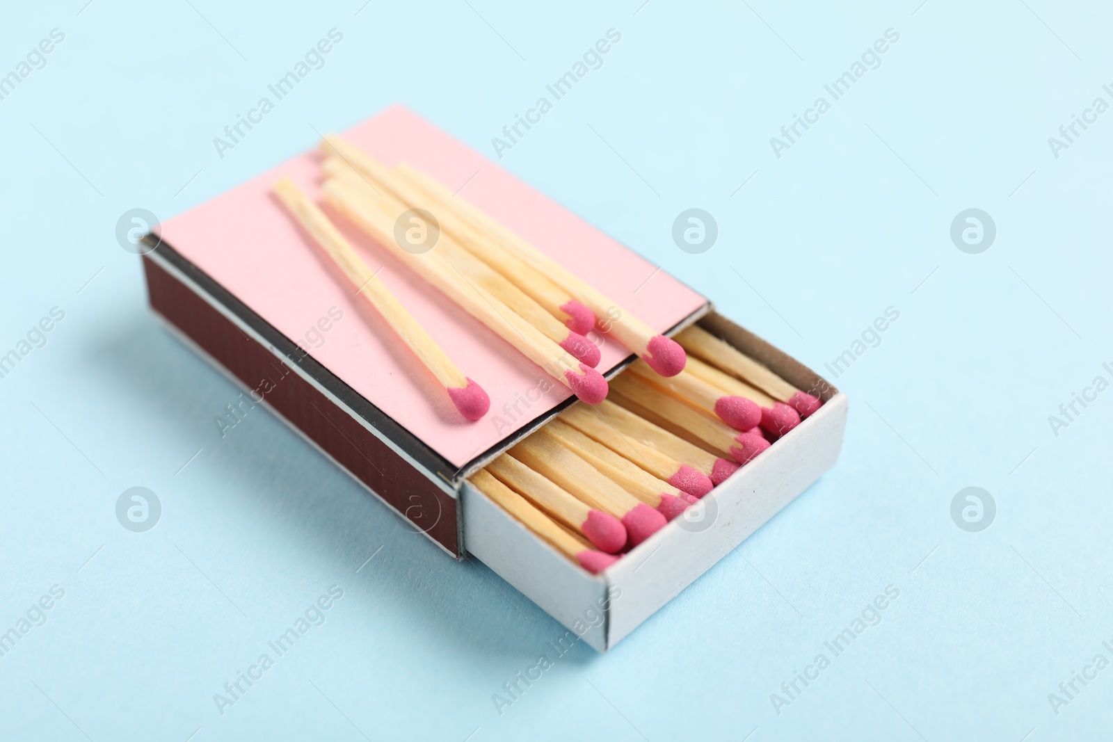 Matches in box on light blue background, closeup Photo of Matches in box on light blue background, closeup