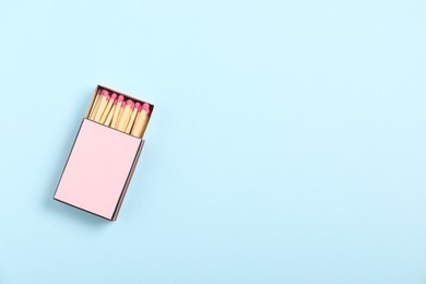 Photo of Matches in box on light blue background, top view. Mockup for design